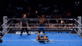 a wrestler in a wrestling ring with a referee in front of a sign that says ' n live '