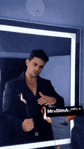 a man in a suit is standing in front of a mirror holding a lit candle .
