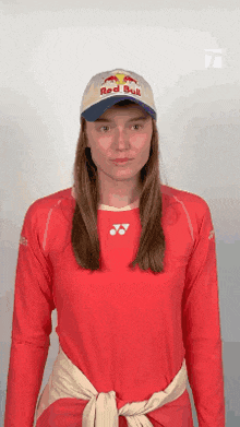 a woman wearing a red bull shirt and a red bull hat