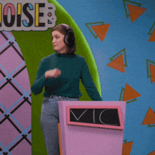 a woman wearing headphones stands in front of a sign that says noises