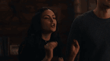 a man and a woman are standing next to each other and the man is wearing a black beanie