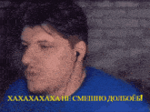 a man wearing ear buds and a blue shirt has a foreign language caption