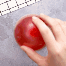 a close up of a person holding a red ball