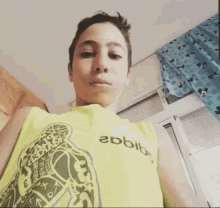 a boy wearing a yellow tank top that says ebbib on it