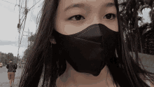a young girl wearing a black face mask