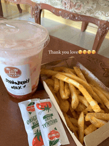 a cup of strawberry milk next to a box of fries