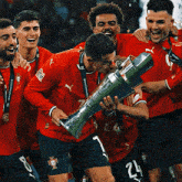 a group of soccer players holding a trophy with the number 24 on the shorts
