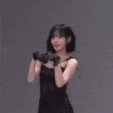 a woman in a black dress and gloves is dancing with another woman in a black dress .