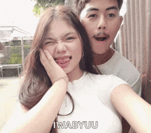 a man and a woman are posing for a picture with iwabyuu on the bottom