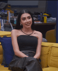 a woman with a tattoo on her arm is sitting on a couch
