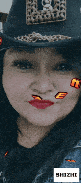 a woman wearing a cowboy hat has a sticker on her face that says " shizhi "