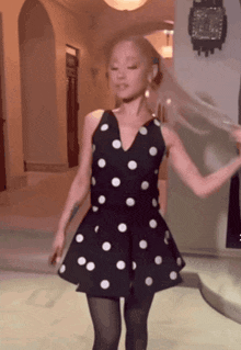 a woman in a black and white polka dot dress