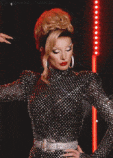 a woman in a polka dot dress is standing in front of a red light and the word tumblr is on the bottom right