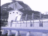 a blurry picture of a white building with a fence in front of it