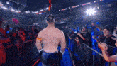 a wrestler is walking through a crowd with a sign that says ' i 'm not a man ' on it