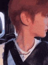 a close up of a person 's neck while wearing a seat belt in a car .