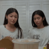 two women sitting next to each other with one wearing a shirt that says swag on it