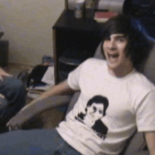 a young man wearing a white shirt with a picture of a boy on it