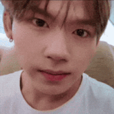 a close up of a person 's face with a white shirt on .