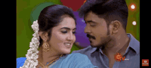 a man and a woman are looking into each other 's eyes with the sun tv logo in the corner