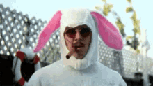 a man wearing a bunny costume is smoking a cigarette .