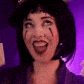 a woman with black hair and red lipstick is smiling and looking up at the camera .