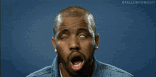 a man in a denim jacket is making a funny face with the hashtag fallontonight
