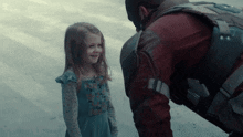 a little girl is smiling at a man in a military uniform