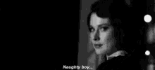 a black and white photo of a woman talking to a boy .