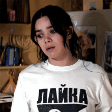 a woman wearing a white t-shirt that says " лайка "