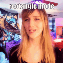 a woman in a black shirt says rectangle mode in front of a butterfly wall hanging