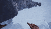 a person 's hand is pointing at a statue in a game