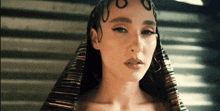 a close up of a woman 's face with a striped headpiece on