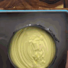 a close up of a bowl of yellow liquid