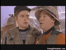 a couple of men are standing next to each other with their mouths open .