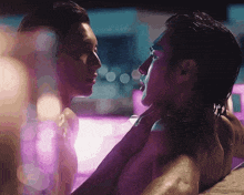 a man and a woman are kissing in a swimming pool