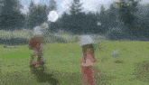 a man and a little girl are standing in a field .