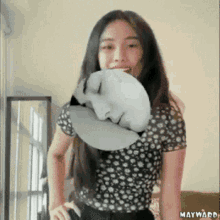 a woman in a black and white polka dot shirt has a picture of a face on her face