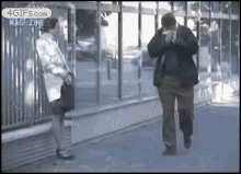 a man and a woman are standing next to each other in front of a building that says magazine on it