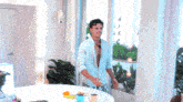 a shirtless man is standing in front of a window in a living room
