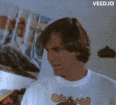 a man is wearing a moose t-shirt and making a face .