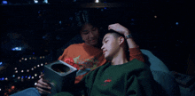 a man wearing a green sweatshirt that says ' tommy hilfiger ' on the front