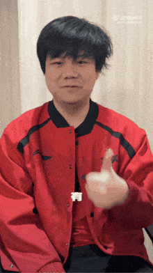 a man in a red jacket giving a thumbs up sign