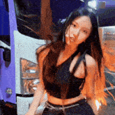 a woman in a black crop top is standing in front of a truck