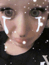 a close up of a girl 's face with a tear on her cheek