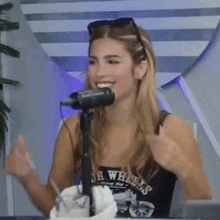a woman is sitting in front of a microphone smiling .