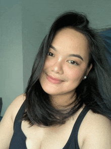 a woman wearing a black tank top is smiling for the camera