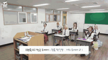 a group of girls sit at desks in a classroom with a toi logo on the top