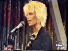 a woman singing into a microphone with the words pravo 's club on the bottom left