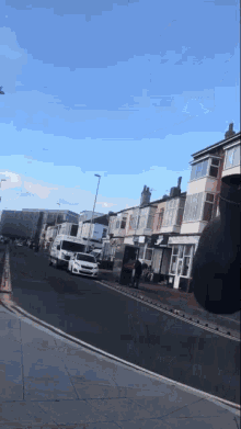 a row of white vans are parked on the side of a street